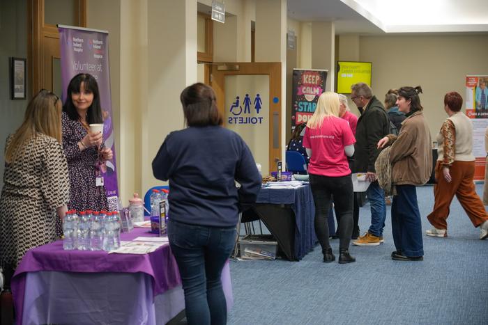 Visitors walking through the fair past exhibition banners