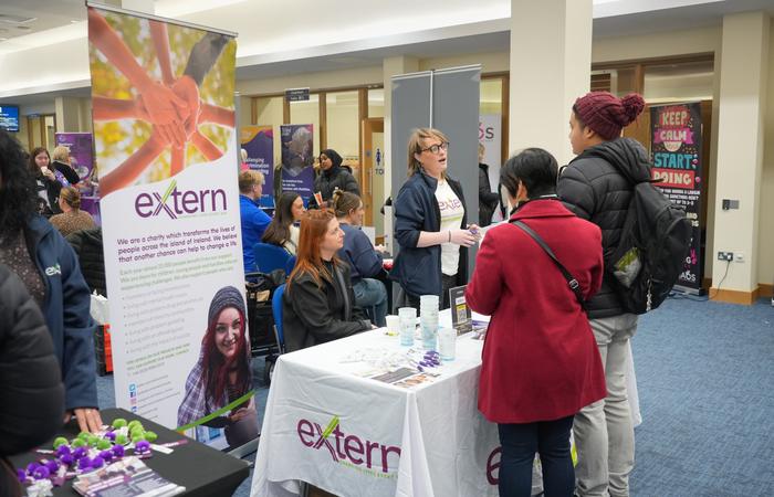 A crowd of visitors around the Extern stand