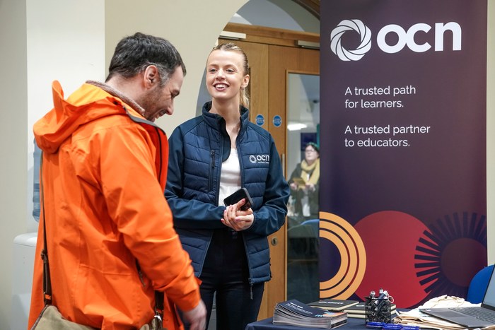 A visitor in conversation with an exhibitor at the OCN Northern Ireland stand