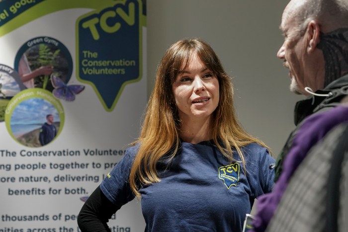 A representative from The Conservation Volunteers speaking with a visitor at their stand