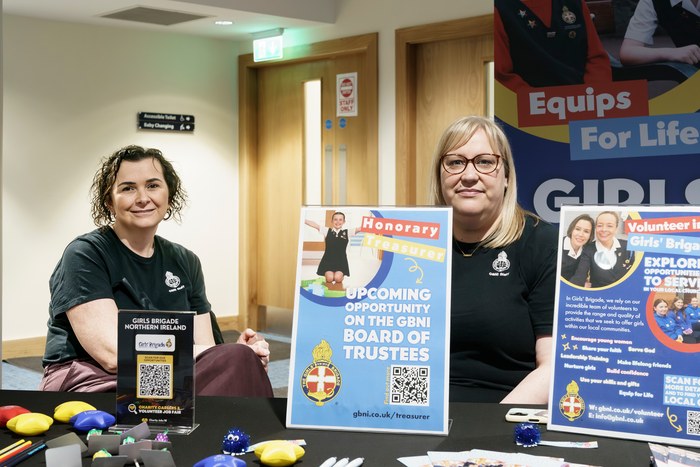 Two exhibitors at a stand promoting trustee and board opportunities